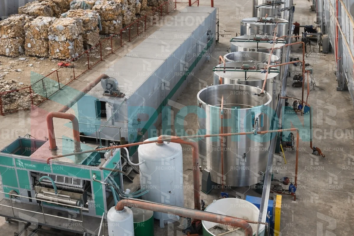Pulp preparation tanks and connected equipment beside stored waste paper